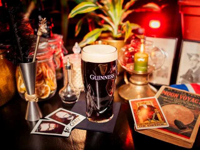 Ein Guinness auf der Bar, umgeben von Polaroids, getrockneten Zitrusfrüchten und alten Büchern
